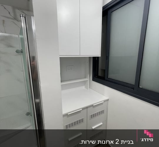 ארון לבן עם מגירות ליד חלון זכוכית